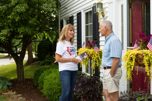 Patty Smith speaking with a resident at their front door in Ward 8