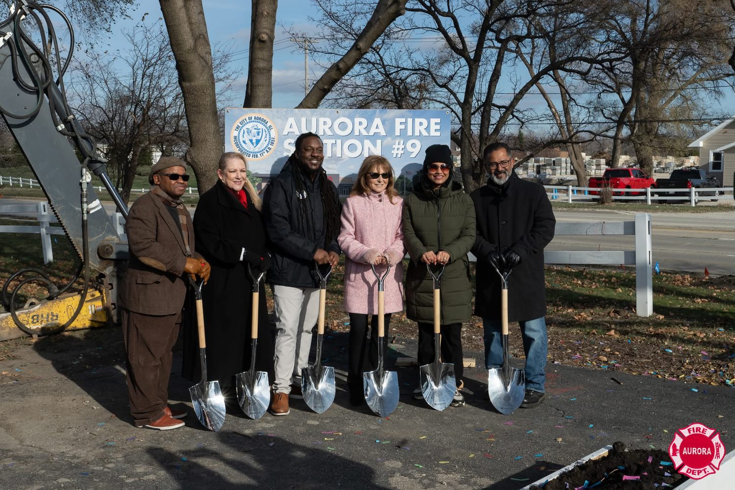 Patty Smith, in a pink coat, with five others holding ceremonial shovels at the groundbreaking for Aurora Fire Station #9